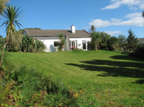 Haus mit Blick auf die Kenmare Bucht umgeben von subtropischer Vegetation